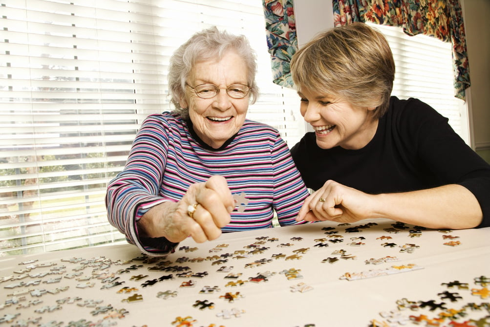 Elderly Woman and Younger Woman Doing Puzzle